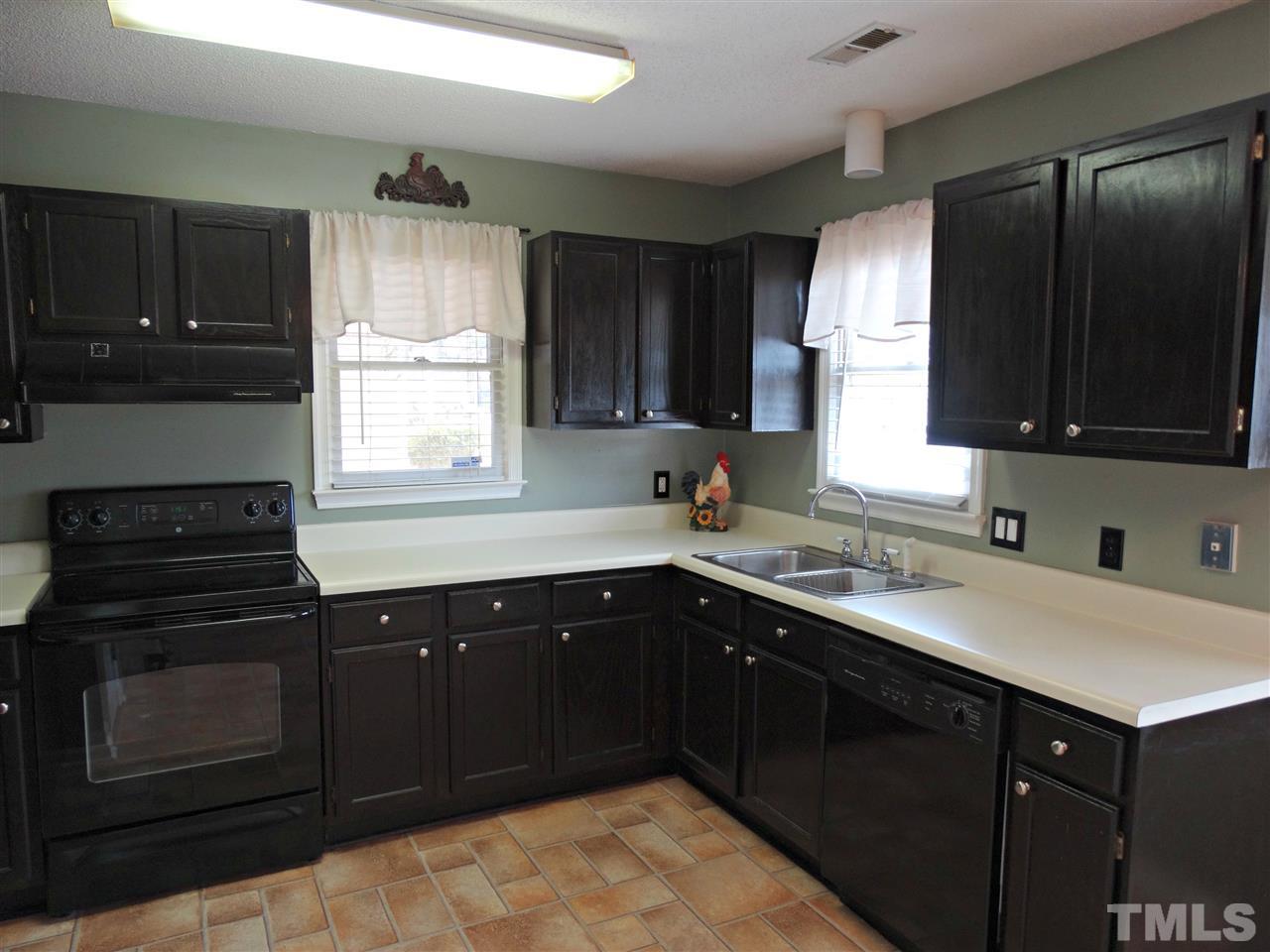 109 Longneedle Court Raleigh, NC 27603 - Photo 11 of 23 a kitchen with a sink stove top oven and cabinets