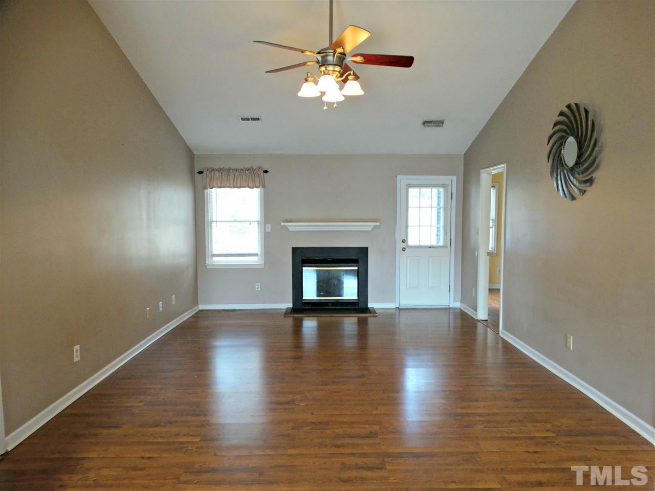109 Longneedle Court Raleigh, NC 27603 - Photo 8 of 23 a view of a room with wooden floor a chandelier fan and windows