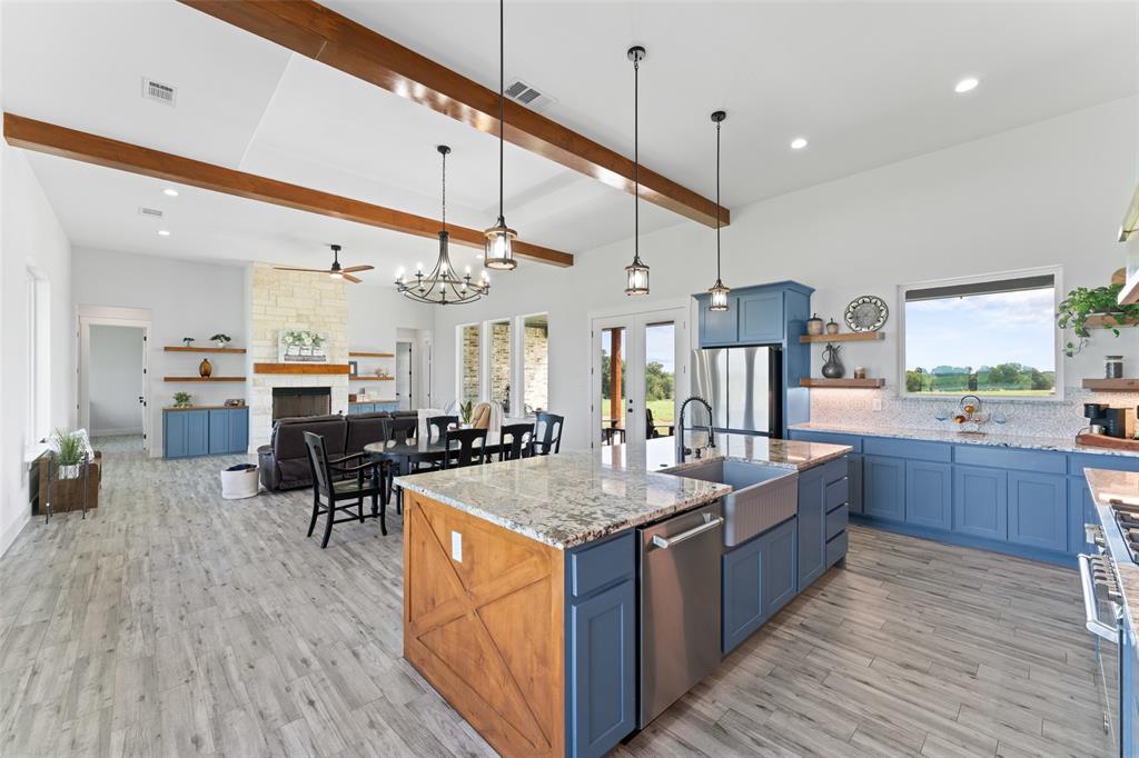 4411 Fm 751 Wills Point Wills Point, TX 75169 - Photo 15 of 40 Expansive kitchen and living area featuring a large center island with a farmhouse sink, stainless steel appliances, and blue cabinetry