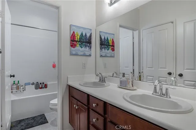 a bathroom with a double vanity sink and a mirror