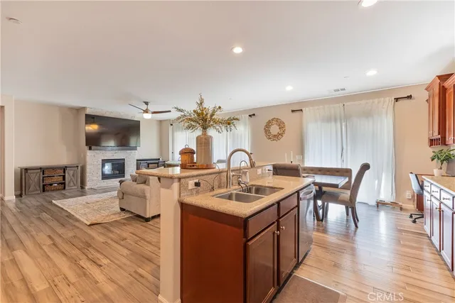 a open kitchen with stainless steel appliances granite countertop a table chairs and a refrigerator
