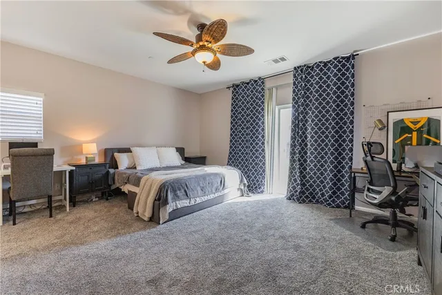a spacious bedroom with a bed and a chandelier