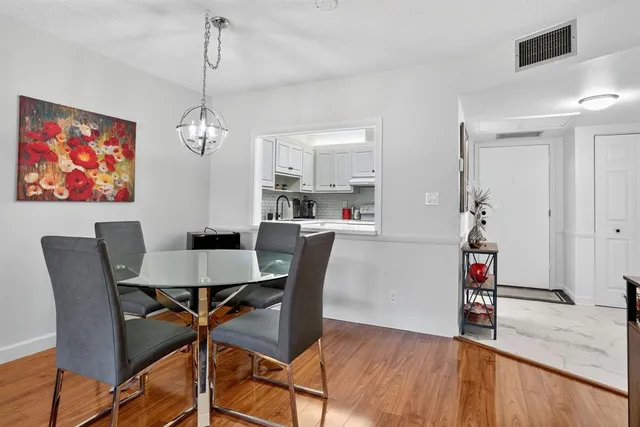 a view of a dining room with furniture wooden floor and a chandelier