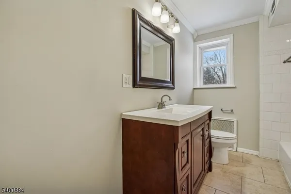 a utility room with a sink a toilet and mirror