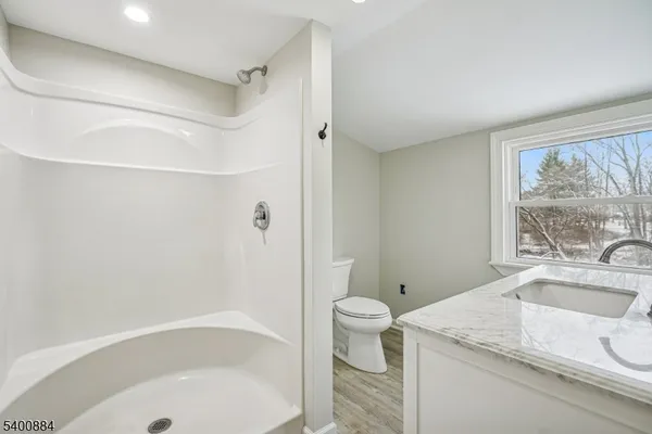 a bathroom with a granite countertop sink toilet and shower