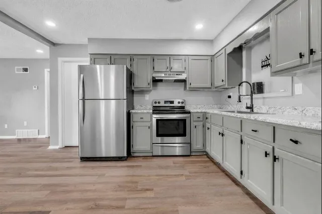 a kitchen with stainless steel appliances a refrigerator sink and cabinets