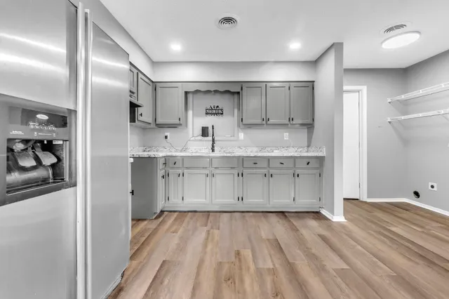 a kitchen with stainless steel appliances sink refrigerator and cabinets