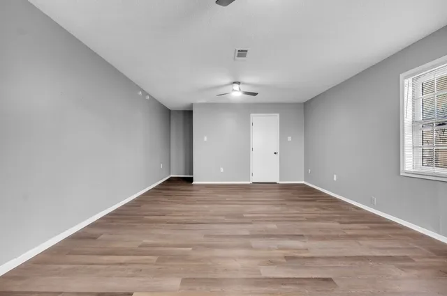 wooden floor in an empty room with a window