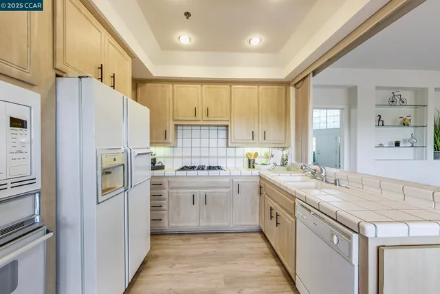 a kitchen with a table chairs refrigerator and cabinets