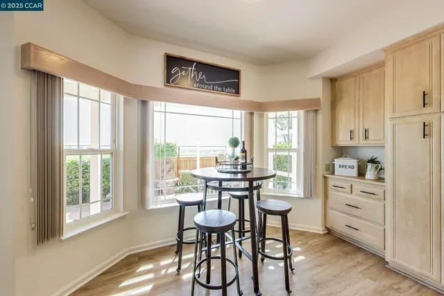 a kitchen with a table chairs refrigerator and cabinets