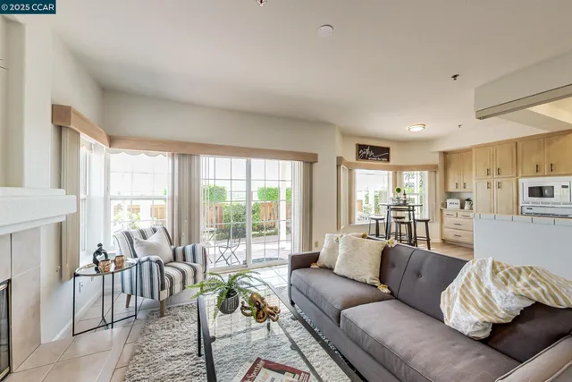 a living room with furniture a large window and a fireplace