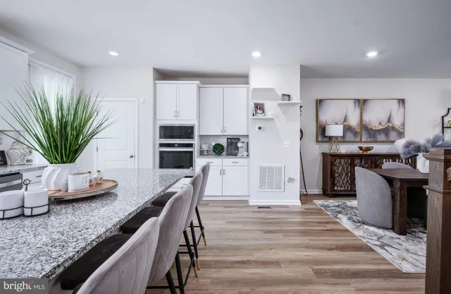 a kitchen with stainless steel appliances granite countertop a refrigerator a stove and a wooden floors