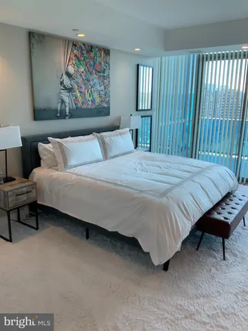 a bedroom with a bed and a painting on the wall