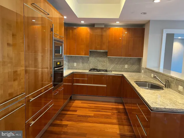 a bathroom with a granite countertop sink and a large mirror