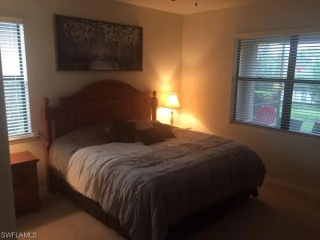 a bedroom with a bed lamp and window