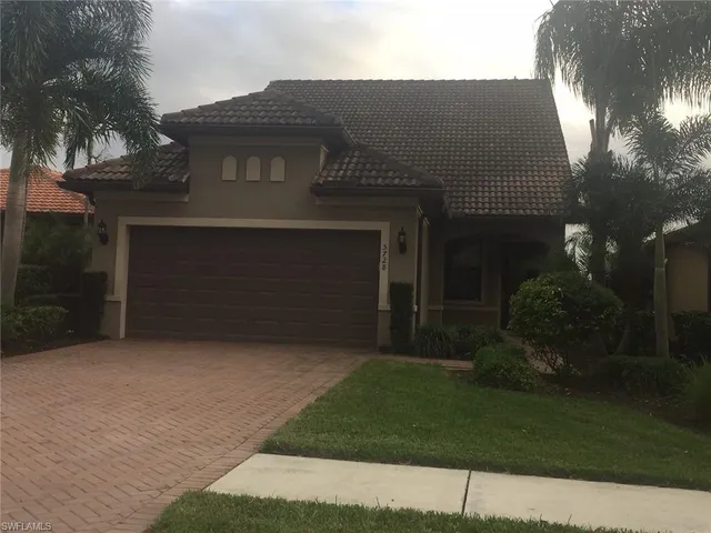 a front view of a house with a garden and yard