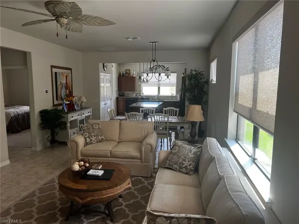 a living room with furniture a chandelier and a large window