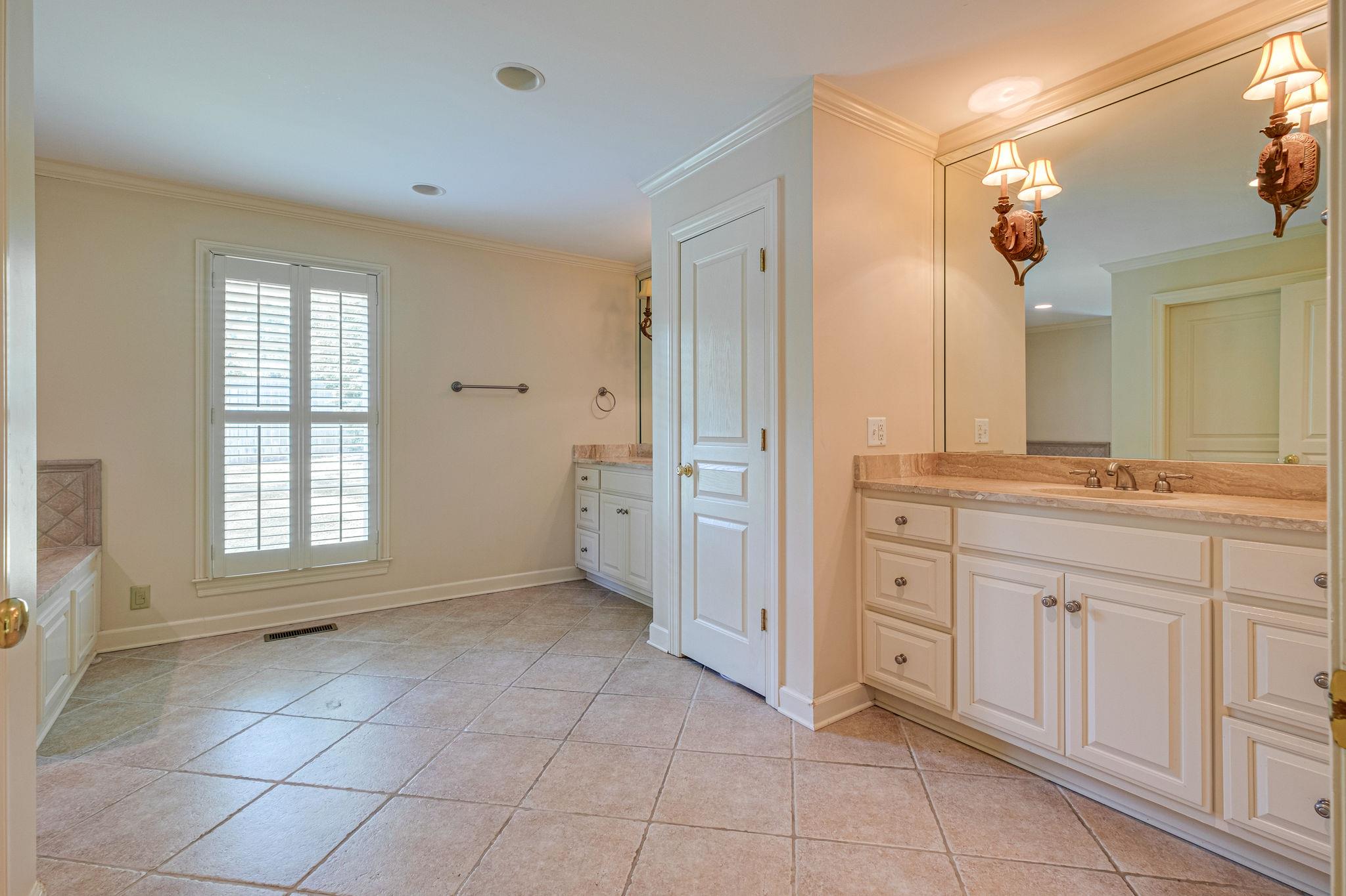 129 Cheek Road Nashville, TN 37205 - Photo 22 of 30 a spacious bathroom with a granite countertop sink a mirror and a bathtub