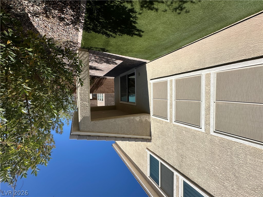 6784 Pivot Point Street Las Vegas, NV 89148 - Photo 26 of 27 A well-maintained side yard features an inviting patio area, artificial turf, and mature landscaping.