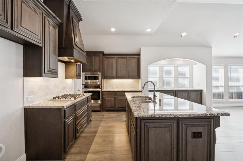 1036 Sandy Hill Burleson, TX 76028 - Photo 12 of 37 a kitchen with stainless steel appliances granite countertop a sink stove and cabinets