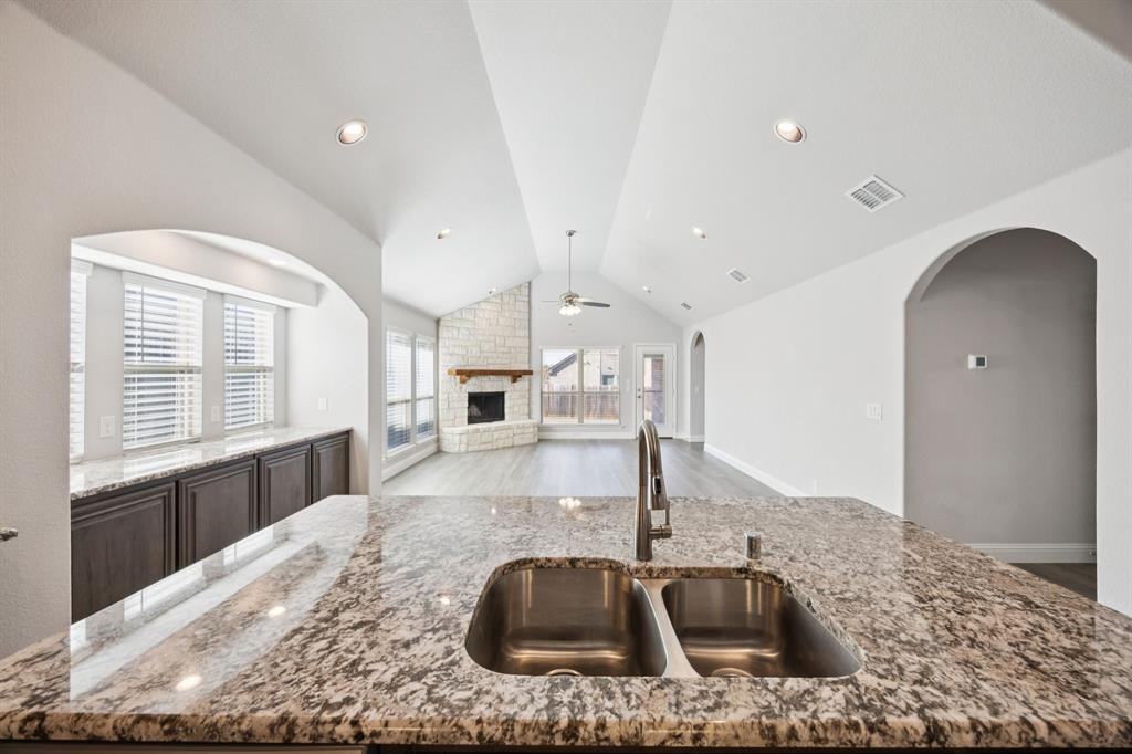 1036 Sandy Hill Burleson, TX 76028 - Photo 13 of 37 a kitchen with kitchen island a sink and a stove top oven
