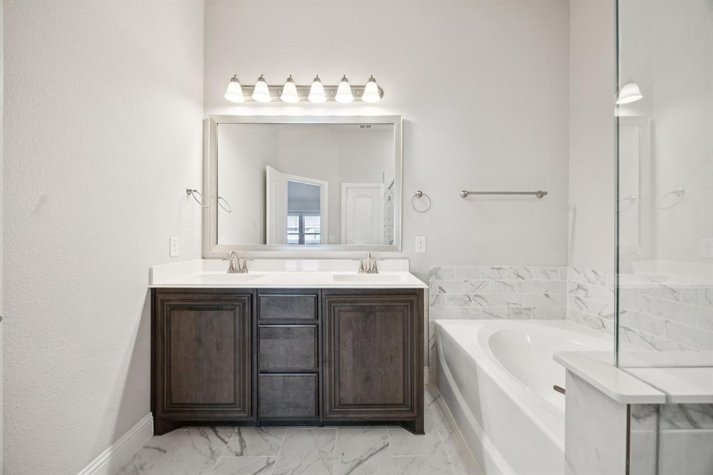 1036 Sandy Hill Burleson, TX 76028 - Photo 24 of 37 a bathroom with a bathtub sink and mirror