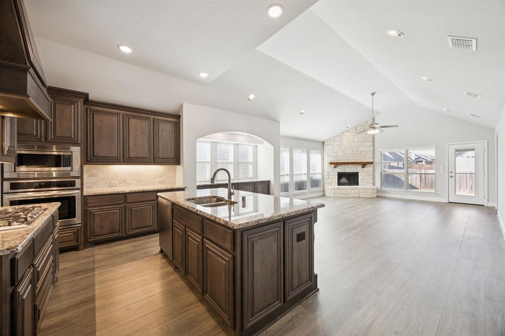 1036 Sandy Hill Burleson, TX 76028 - Photo 8 of 37 a kitchen with kitchen island granite countertop a stove top oven a sink a counter space and cabinets