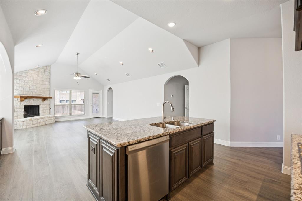 1036 Sandy Hill Burleson, TX 76028 - Photo 9 of 37 a kitchen with stainless steel appliances granite countertop a sink a stove and a wooden floors