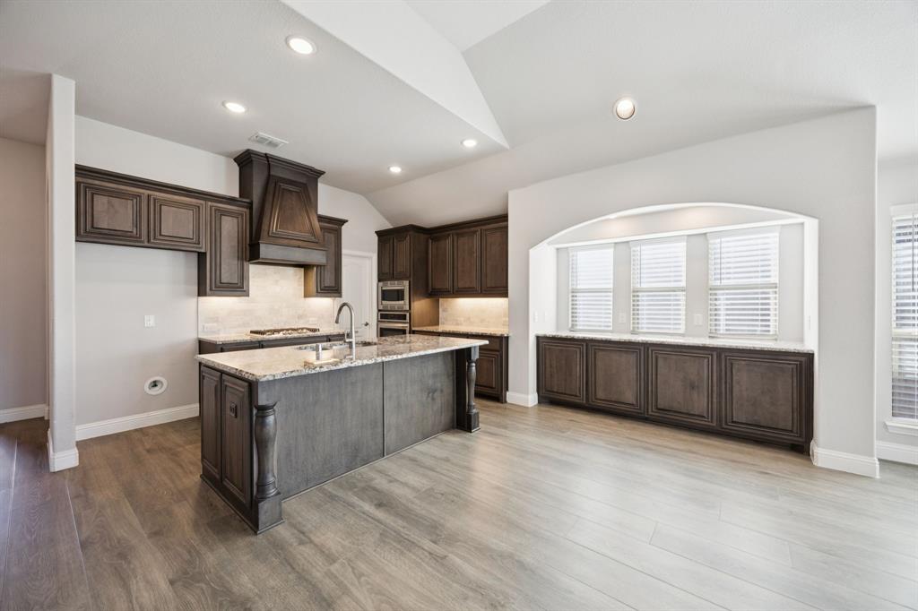 1036 Sandy Hill Burleson, TX 76028 - Photo 10 of 37 a large kitchen with stainless steel appliances granite countertop a lot of cabinets and wooden floor