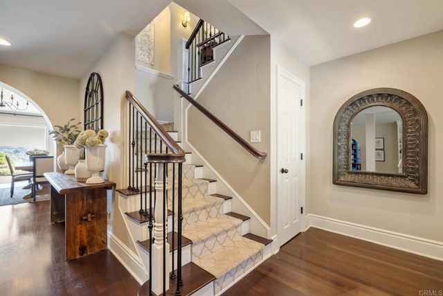 a view of a hallway with entryway wooden floor and windows