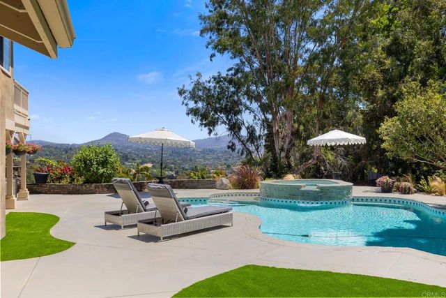 a view of a house with backyard sitting area and swimming pool