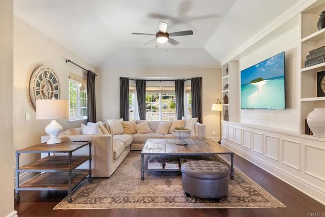 a living room with furniture a flat screen tv and a window