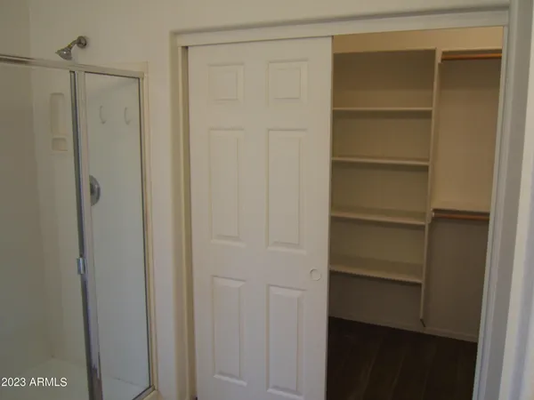 a view of walk in closet with empty racks
