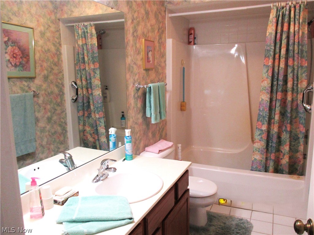 7540 Kennard Road Seville, OH 44273 - Photo 22 of 37 Full bathroom with tile floors, shower / bath combination with curtain, vanity, and toilet