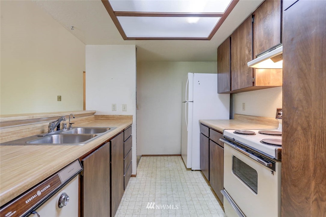 14401 Southeast Petrovitsky Road, Unit F203 Renton, WA 98058 - Photo 6 of 16 a kitchen with a sink stove and cabinets