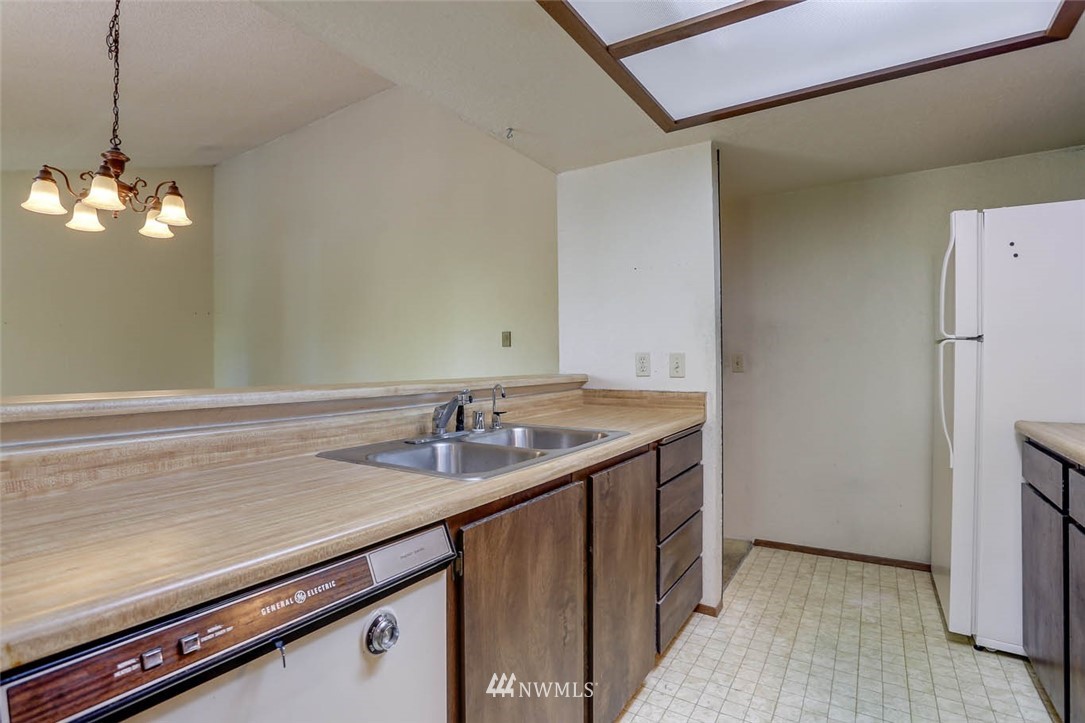 14401 Southeast Petrovitsky Road, Unit F203 Renton, WA 98058 - Photo 7 of 16 a sink with a wooden cabinets