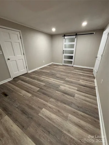 a view of empty room with wooden floor