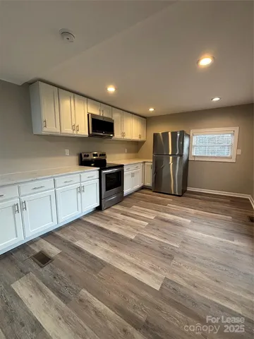 a large kitchen with kitchen island a sink stainless steel appliances and cabinets