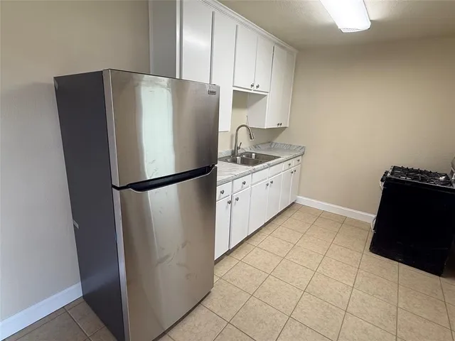 a kitchen with stainless steel appliances a refrigerator sink and cabinets