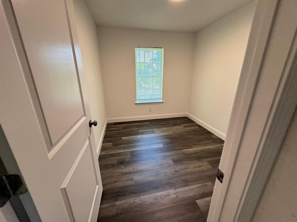 312 West Rentz Street, Unit 99 Weatherford, TX 76086 - Photo 5 of 7 Spare room with dark wood finished floors and baseboards