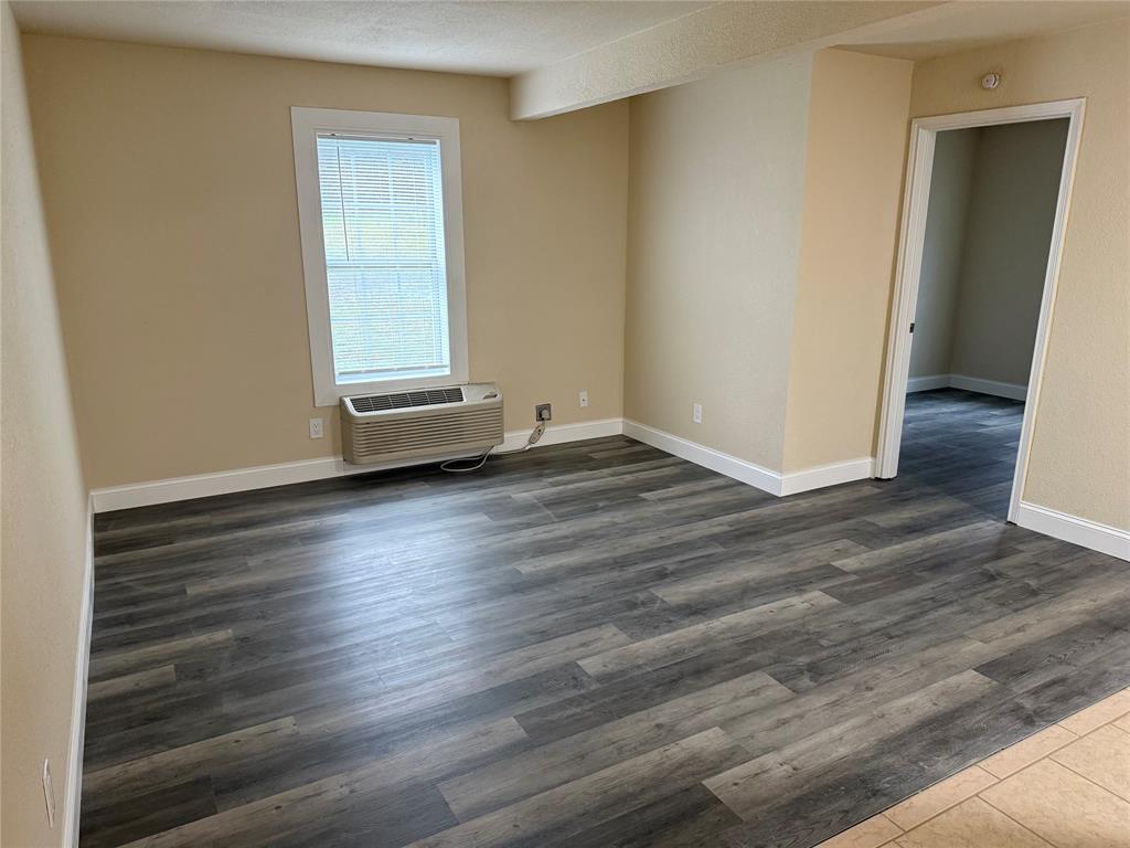 312 West Rentz Street, Unit 99 Weatherford, TX 76086 - Photo 5 of 7 an empty room with wooden floor and windows