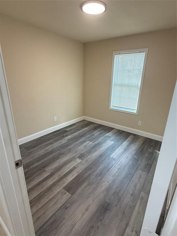 312 West Rentz Street, Unit 99 Weatherford, TX 76086 - Photo 6 of 7 an empty room with wooden floor and windows