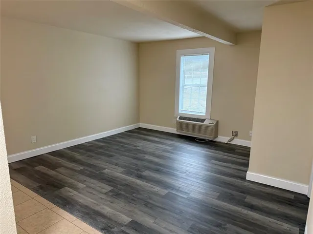 a view of a room with wooden floor and window