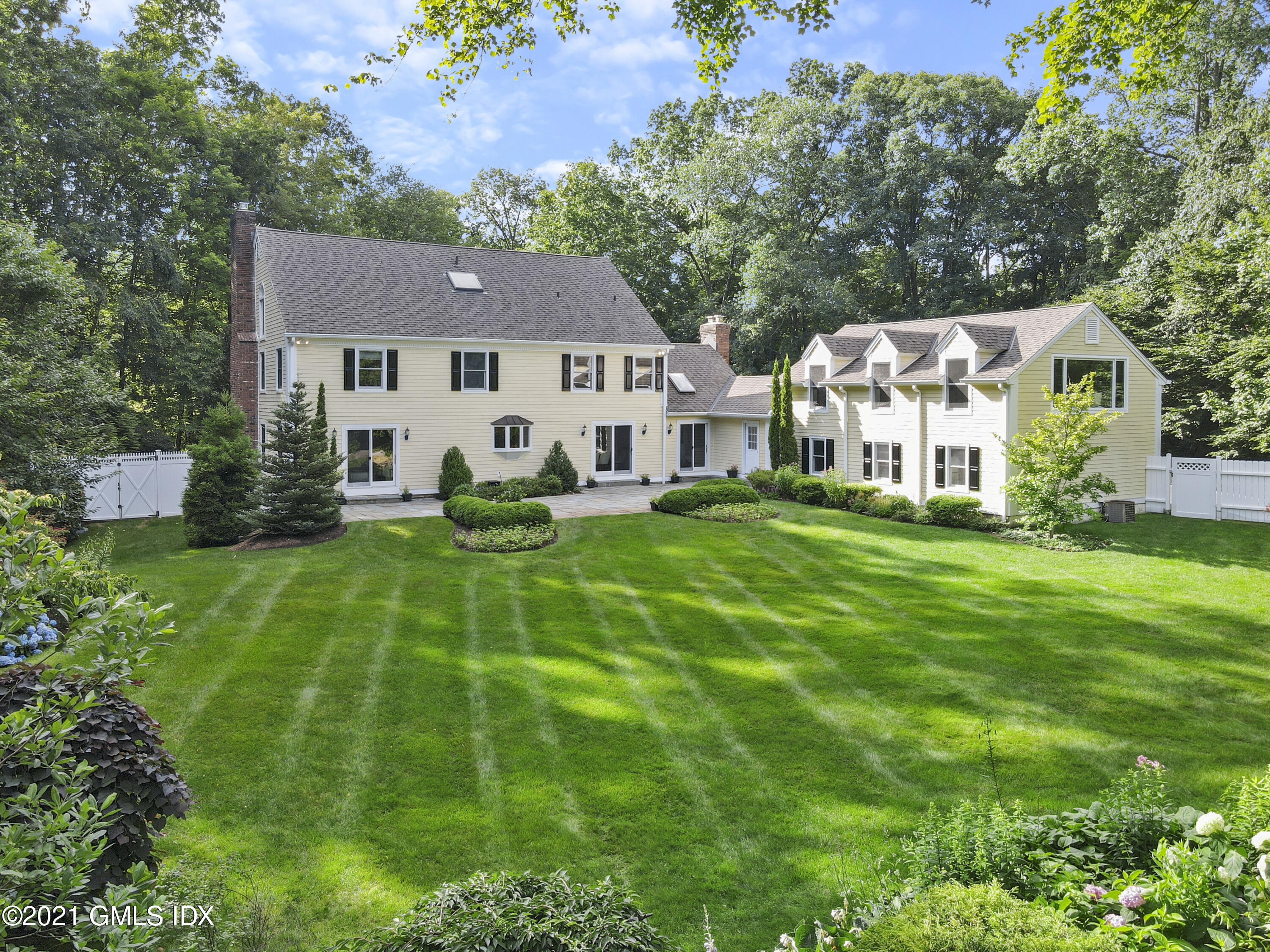 150 Porchuck Road Greenwich, CT 06831 - Photo 20 of 21 a front view of a house with a yard table and chairs