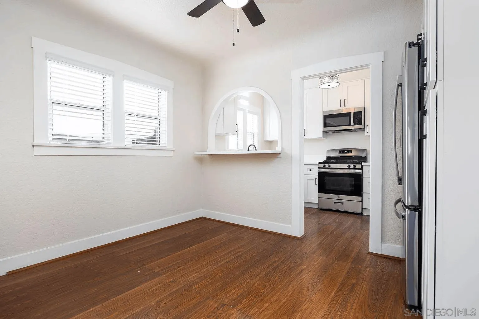 8655 Valencia Street Spring Valley, CA 91977 - Photo 4 of 14 an empty room with wooden floor a ceiling fan and windows