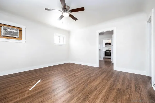 a view of empty room with wooden floor