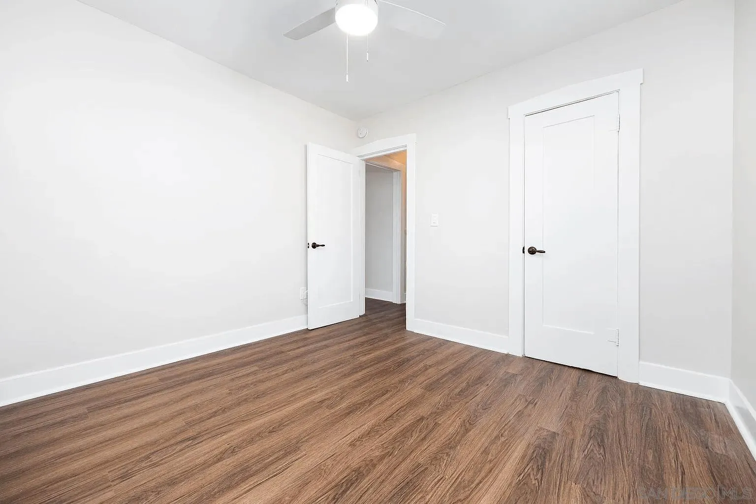 8655 Valencia Street Spring Valley, CA 91977 - Photo 7 of 14 an empty room with wooden floor and a ceiling fan