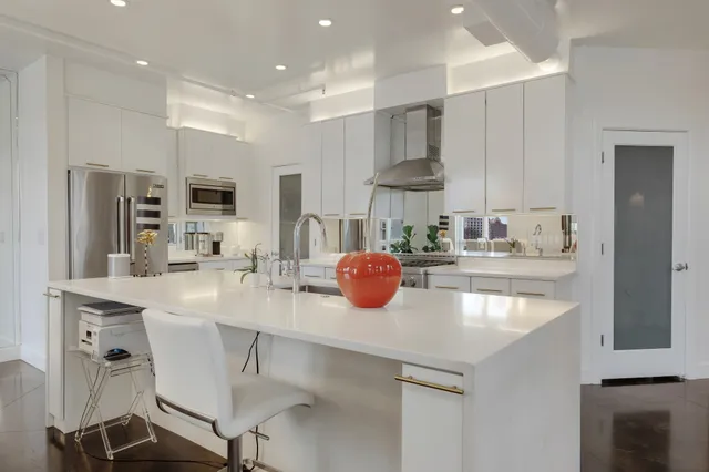 a kitchen with kitchen island a sink a stove a refrigerator cabinets and a counter top space