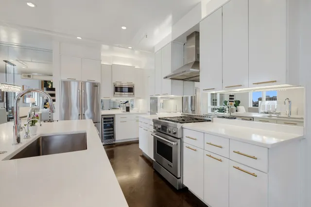 a kitchen with stainless steel appliances white cabinets and a refrigerator