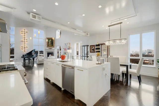a large white kitchen with lots of counter space and furniture